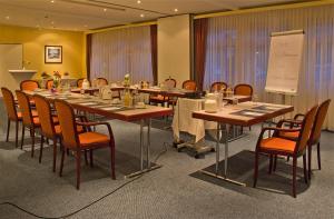 una sala de conferencias con una mesa larga y sillas en Hotel Kreuzer en Wedel