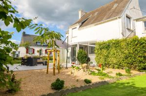 einen Garten mit Spielplatz vor einem Haus in der Unterkunft Vacances Bigoudenes pour 6 ! in Loctudy