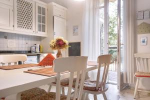 uma cozinha com uma mesa e cadeiras brancas e uma sala de jantar em Suite in villa con parco em Varese