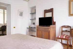 Un dormitorio con una cama y un televisor de pantalla plana. en Suite in villa con parco, en Varese