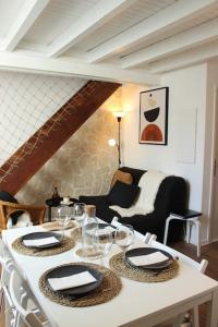 Biały stół z krzesłami i stół z kieliszkami do wina w obiekcie Le P'tit Hélios 4-6 personnes - Centre ville de Barèges w mieście Barèges