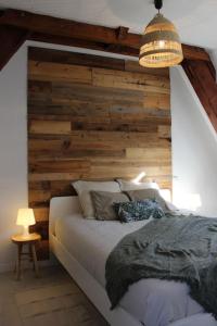 a bedroom with a wooden accent wall and a bed at Le P'tit Hélios 4-6 personnes - Centre ville de Barèges in Barèges