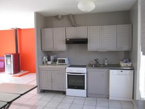 a kitchen with white appliances and an orange wall at Maison avec grand jardin pour 15 couchages en Normandie in Cairon