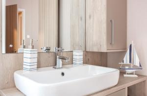 a bathroom with a white sink and a mirror at Lakeside Lodge, Green Hill Farm Holiday Village in Salisbury +27 photos