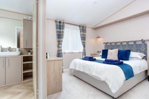 a bedroom with a king sized bed and a sink at Lakeside Lodge, Green Hill Farm Holiday Village in Salisbury