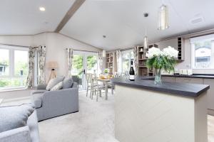a kitchen and living room with a bar and a couch at Lakeside Lodge, Green Hill Farm Holiday Village in Salisbury