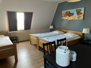 ein Hotelzimmer mit 2 Betten und einem Tisch mit Stühlen in der Unterkunft Hotel De Oude Molen in Groesbeek