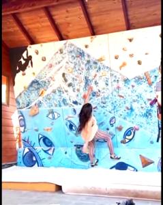 a young girl sitting on a climbing wall at Cabaña con muro de escalada in Pucón