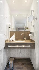 bagno con lavandino e specchio di Hotel Kreuzer a Wedel