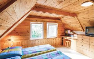 a bedroom in a log cabin with a bed and a desk at Awesome Home In Mragowo With 3 Bedrooms And Wifi in Kosewo