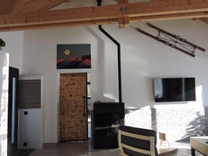 ein Wohnzimmer mit einer Holztür und einem TV in der Unterkunft Magnifique Villa Sabot de Venus in Le Lautaret