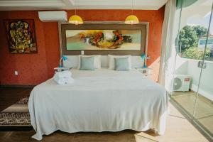 1 dormitorio con 1 cama blanca grande y paredes de color naranja en Villa Terragona en Alto Paraíso de Goiás