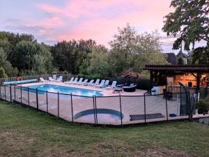a large swimming pool with chairs and a gazebo at Domaine Pagel Gîte nature piscine chauffée vaste jardin avec activités enfants in Catus