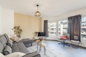 a living room with a couch and a tv at Delightful family apartment at only 50 meters from the beach / Panne A Côte in De Panne