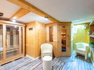 pokój z drewnianymi ścianami i białymi krzesłami w obiekcie Apartment in Bichlbach near Ski Slopes w mieście Bichlbach