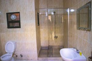 a bathroom with a shower and a toilet and a sink at Sara Crown Hotel in Irbid