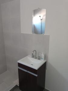 a bathroom with a sink and a mirror at Departamento Chacabuco in San Fernando del Valle de Catamarca