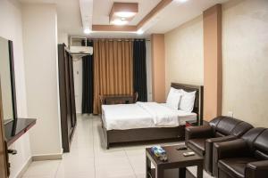 una camera d'albergo con letto e divano di Sara Crown Hotel a Irbid