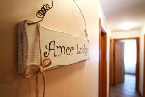 a sign that reads anyone love hanging on a wall at Amor Lodge in Saas-Fee