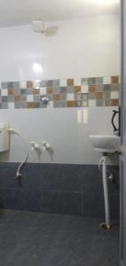 y baño con lavabo y ducha. en Madura Homestay - Gorgeous Home with 2BHK 5 minutes from NH44, en Madurai