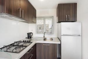 uma cozinha com um fogão e um frigorífico branco em Mobile Home Next 232 em Pietra Ligure