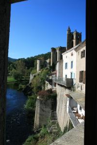 Blick auf einen Fluss mit einem Schloss im Hintergrund in der Unterkunft Hôtel Restaurant du Pêcheur in Lavoûte-Chilhac