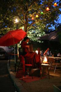 kobieta siedząca na krześle pod parasolką w obiekcie Hôtel Restaurant du Pêcheur w mieście Lavoûte-Chilhac