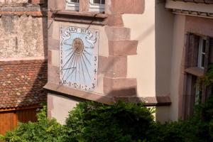 a sign on the side of a building at Domaine La Cour Des Nobles - Demeure, Maison et Appartements au coeur de Riquewihr in Riquewihr