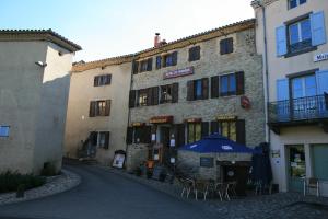 a building with a blue umbrella in a street at Hôtel Restaurant du Pêcheur in Lavoûte-Chilhac