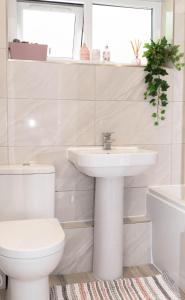 Hale Lodge في لندن: حمام أبيض مع حوض ومرحاض