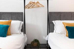 duas camas com almofadas e uma planta sentada entre elas em Hale Lodge em Londres