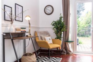 escritorio y silla en una habitación con reloj en la pared en Hale Lodge, en Londres