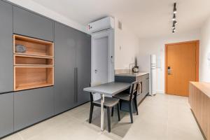 uma cozinha com uma mesa e cadeiras e um frigorífico em LIV - Apartamento 1205 em Porto Alegre