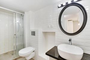a white bathroom with a toilet and a mirror at CMG Cavallotti - Montmartre in Paris