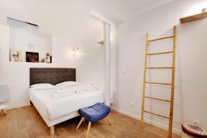 1 dormitorio con cama blanca y taburete azul en CMG Cavallotti - Montmartre, en París