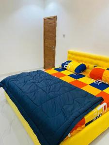 - un lit avec une couette colorée dans une chambre dans l'établissement Mr Luxury 3 Bedroom Apartment, à Lagos