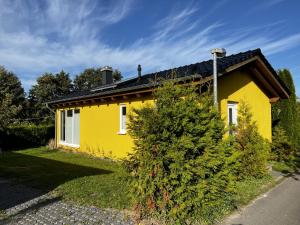 a yellow house with a tree in front of it at Fichtel in Graal-Müritz