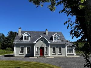 una gran casa blanca con puerta roja en Drumbar Lodge, en Carterʼs Bridge
