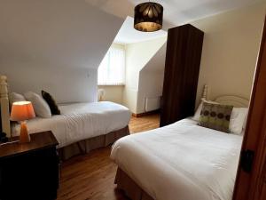a hotel room with two beds and a lamp at Drumbar Lodge in Carterʼs Bridge