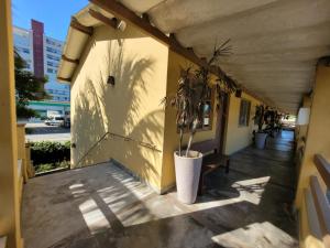 a porch with a potted plant on a building at Condomínio Recanto do Léo in Bertioga