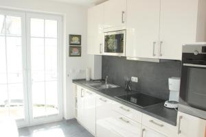 a kitchen with white cabinets and a sink at StrandGut in Boltenhagen