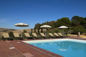 una piscina con tumbonas y sombrillas en Podere San Giuseppe Montalcino, en Montalcino