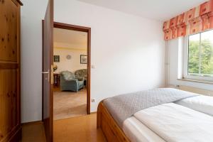 um quarto com uma cama e uma porta que leva a uma sala de estar em Seepark Wohnung 1 1 em Scharbeutz