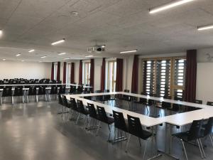 una sala de conferencias con mesas y sillas. en Jugendherberge Heilbronn, en Heilbronn