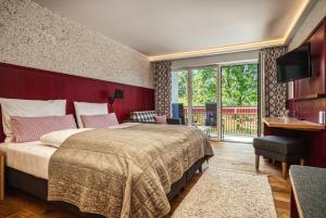 Schlafzimmer mit einem großen Bett mit einem roten Kopfteil in der Unterkunft Landhaus Sommerau in Buchenberg