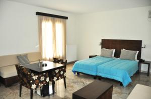 a bedroom with a bed and a table and a desk at Actor Hotel in Ligourio