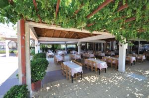 a restaurant with tables and chairs under a pavilion at Actor Hotel in Lygourio