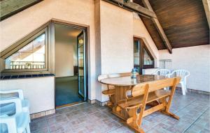 a porch with a wooden table and white chairs at Stunning Home In Rowy With Sauna in Rowy