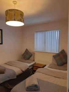 a room with two beds and a window and a light at Belfast Apartment in Belfast