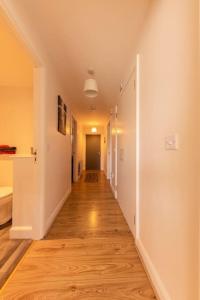 an empty hallway in a home with wood floors at Belfast Apartment in Belfast
